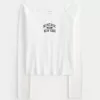 Camiseta gráfica Montauk con hombros descubiertos y ribete de encaje