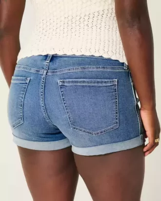 Shorts cortos de mezclilla con lavado medio y tiro bajo con curvas Shorts cortos de mezclilla con lavado medio y tiro bajo con curvas