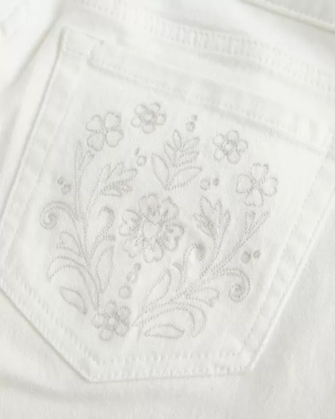 Vaqueros acampanados con bolsillo bordado blanco y tiro ultrabajo Vaqueros acampanados con bolsillo bordado blanco y tiro ultrabajo